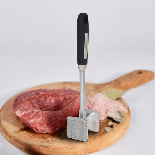 The Jim Beam Dual Side Meat Tenderizer by Jim Beam stands upright on a wooden cutting board next to raw meat, pink salt, and a bay leaf, all set against a white background.