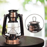 The North Point Vintage LED Lantern with Built-in Dimmer Switch in copper sits on a dark wood table. An inset highlights its metal handle, while the bright, blurred background emphasizes the lantern’s classic charm.