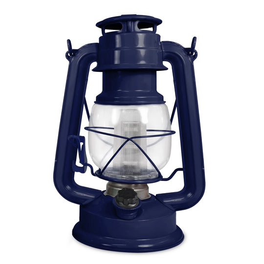 The North Point Vintage LED Lantern by North Point is a classic blue portable lantern with a glass enclosure, metal handle, round base, protective metal frame, and a built-in dimmer switch for adjustable brightness. Shown against a white background.