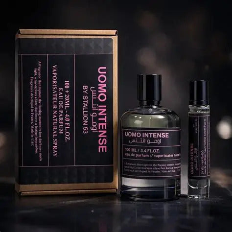 Three items from the North Point Uomo Intense by Stallion 53 Eau de Parfum Spray Gift Set—a brown and black box, a glass perfume bottle with black cap, and a slim spray vial—are elegantly arranged on a dark surface.