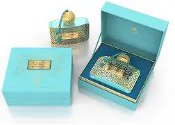 A turquoise and gold Casabella Moonlight Eau de Parfum Spray for Women 3.4 OZ by North Point stands beside an ornate perfume bottle with a tassel and gold accent, set against a neutral backdrop with dried plants for a feminine touch.
