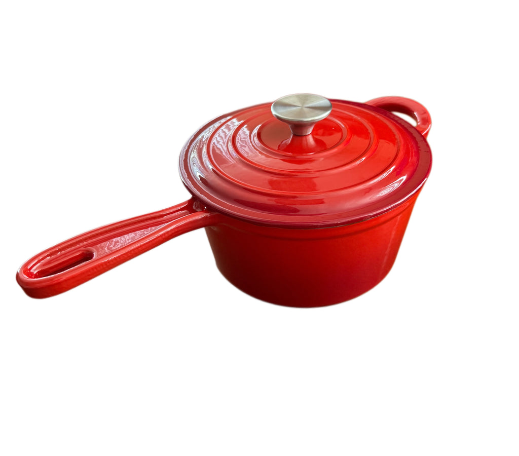 The North Point 2 Qt Enameled Cast Iron Saucepan in red features a long handle, matching lid with metal knob, self-basting design, and nonstick, oven-safe construction. Perfect for versatile cooking. Isolated on a white background.