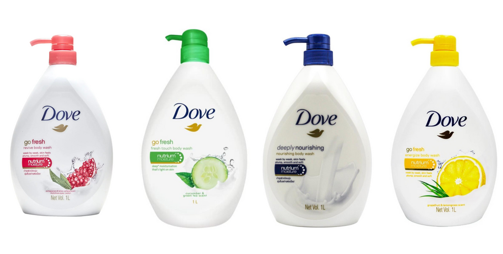 Four North Point Dove Body Wash 1L bottles, each with a unique colored pump and label: pomegranate, cucumber & green tea, deeply nourishing (white swirl), and lemon scent. Each variant offers a different fragrant experience.