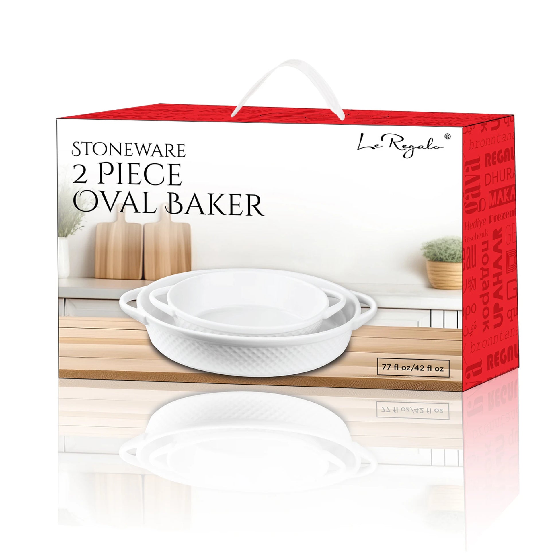 The Le Regalo 2 Piece Stoneware Oval Baker Set features two white stoneware baking dishes with handles, shown on a kitchen countertop beside wooden utensils and a potted plant.