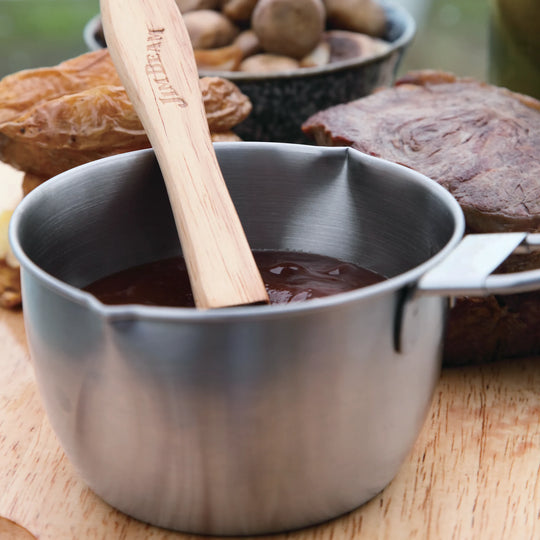 The Jim Beam Stainless Steel Basting Pot Set features a stainless basting pot with handle and a wooden-handled brush with red silicone bristles, both displayed on a white background.