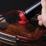 A hand uses the Jim Beam Vacuum Seal Marinade Container to remove air via the lid’s valve, sealing in flavor—an essential BBQ accessory from Jim Beam for marinating meat.