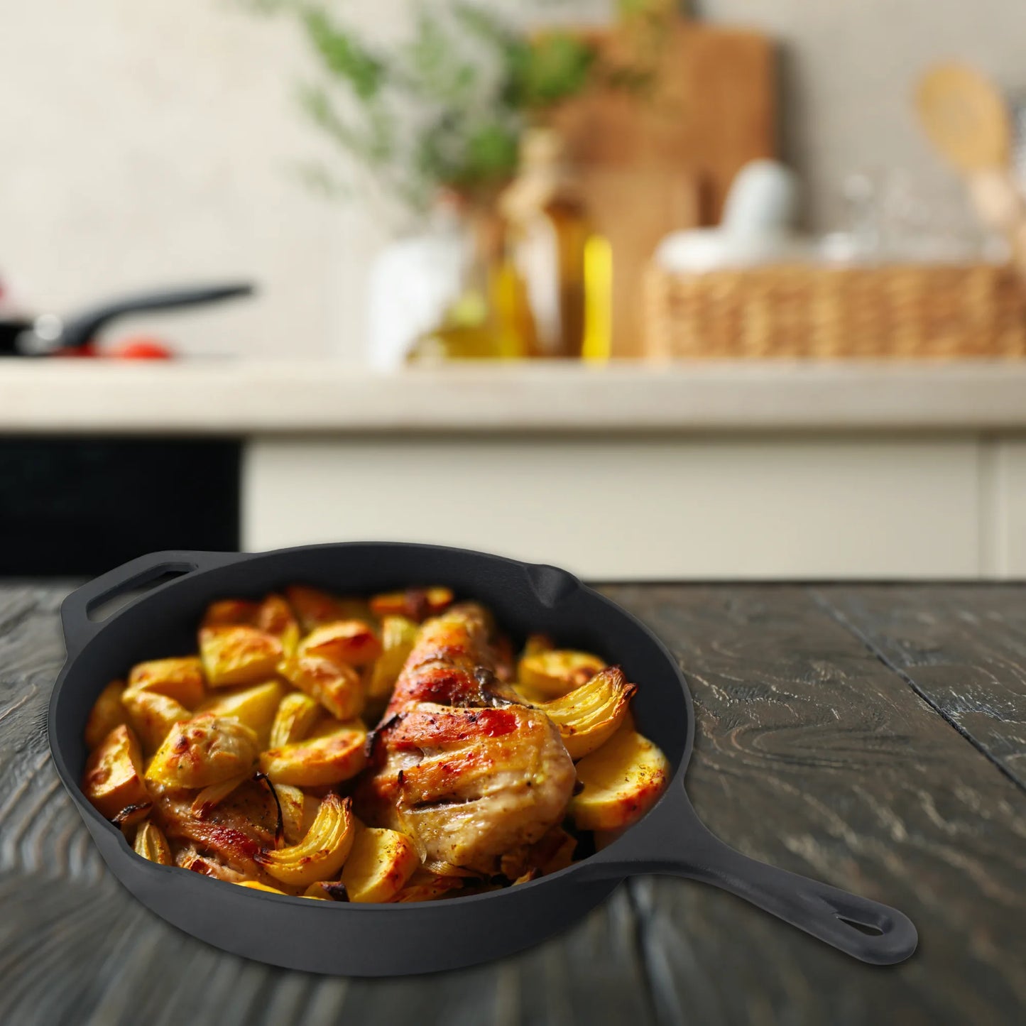 The Jim Beam Cast Iron 10.25 Skillet, pre-seasoned and filled with roasted chicken and golden potatoes, rests on a dark wooden table with a blurred kitchen background—a true essential from Jim Beam.