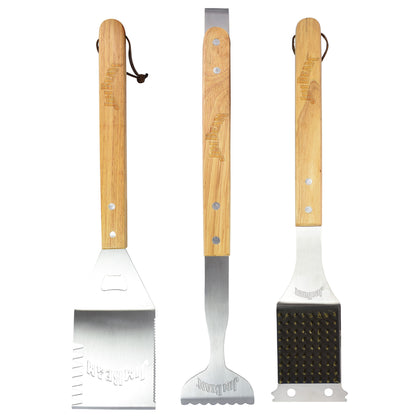 Three barbecue tools with wooden handles, including a spatula, grill brush, and tongs, on a white background.