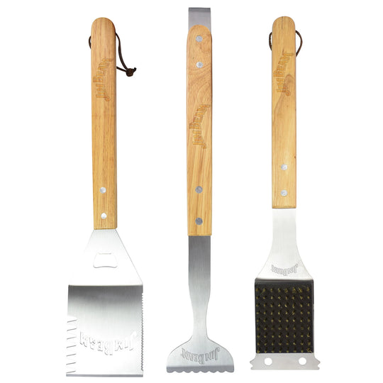 The Jim Beam 3-Piece BBQ Tool Set is shown with stainless steel tools and wooden handles: a spatula on the left, tongs in the center, and a grill cleaning brush with brass bristles on the right.