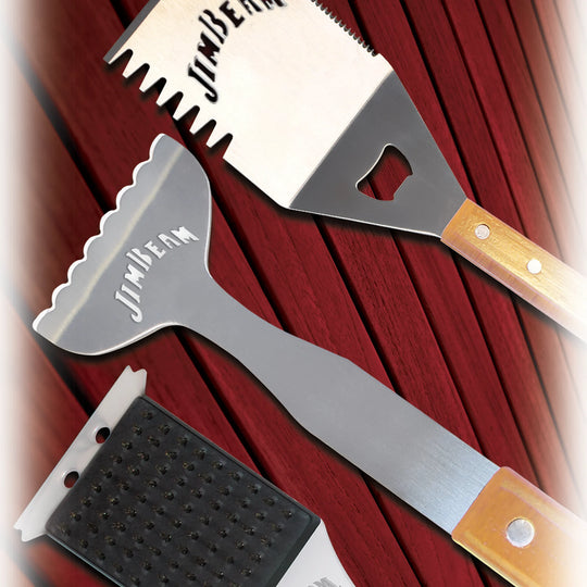 The Jim Beam 3-Piece BBQ Tool Set is shown with stainless steel tools and wooden handles: a spatula on the left, tongs in the center, and a grill cleaning brush with brass bristles on the right.