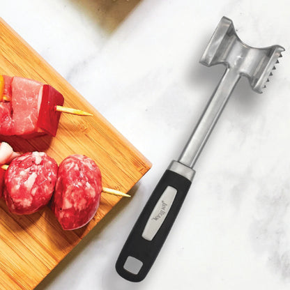 The Jim Beam Dual Side Meat Tenderizer by Jim Beam, featuring a black handle, rests on a white surface next to a wooden cutting board with raw meat skewers.