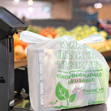 Eco-Friendly Oxo-Biodegradable T-Shirt Carry Bag with  "Thank You" text written is placed on a weighing machine with some product inside the bag