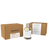 A clear bottle of Emper Unisex Stallion 53 EDP Spray 3.4 oz with a black cap is displayed before two brown boxes labeled Stallion 53, showcasing its sleek white-label design and luxurious fragrance.