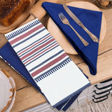 A fork and knife rest on a blue cloth napkin folded into a triangle beside the Textilia 4 Piece Kitchen Towel Set by Textilia, all arranged on a wooden table near a loaf of bread and a plate.
