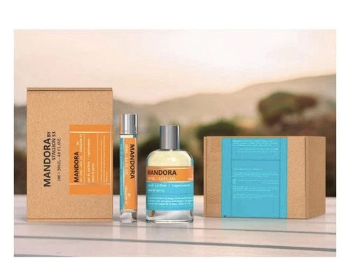 The Mandora by Stallion 53 Eau de Parfum Spray Gift Set by North Point features a refined fragrance set, including a spray and glass bottle, elegantly displayed on a white surface with a blurred landscape in the background.